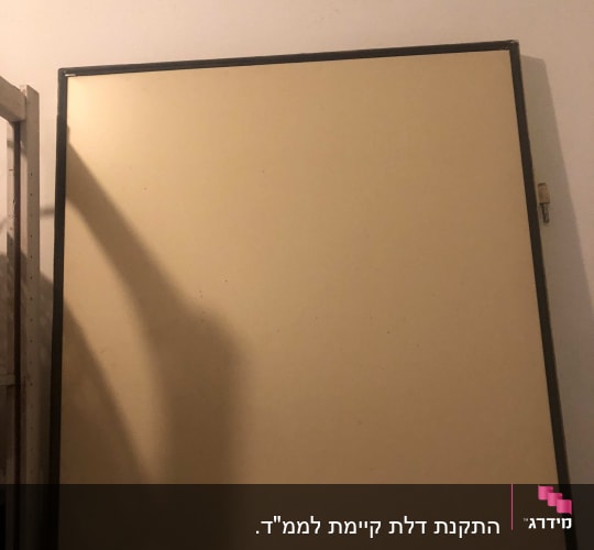 דלת פשוטה עם צל על הקיר